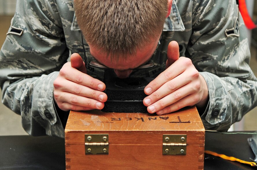 Airman Justin Schiraldi, 2nd Operations Support Squadron aircrew flight equipment apprentice, checks the luminescence points on a compass in a flight crew survival kit at Barksdale Air Force Base, La., Jan. 5. In addition to survival kits, members of aircrew flight equipment maintain, inspect, repair and pack equipment such as helmets, masks, parachutes, floatation devices and night-vision devices. (U.S. Air Force photo/Senior Airman Joanna M. Kresge)
