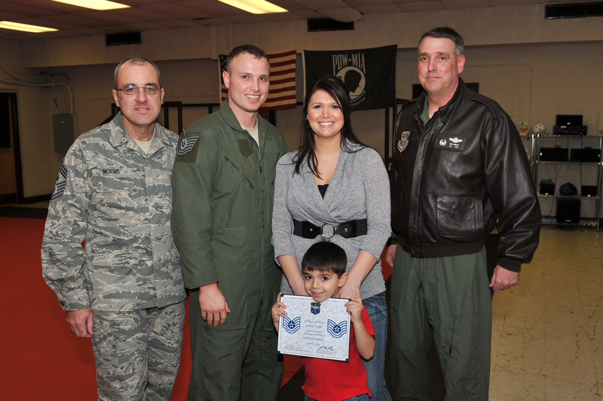 (From left) Chief Master Sgt. James Morris, 19th Airlift Wing command chief, Staff Sgt. Joshua Taylor, 50th Airlift Squadron loadmaster, his wife, Sarah, son, Jacob, and Col. Mike Minihan, 19th AW commander, pose for a photo Jan. 4, 2011, at Little Rock Air Force Base, Ark. Sergeant Taylor was promoted to technical sergeant through the Stripes for Exceptional Performers program. (U.S. Air Force photo by Staff Sgt. Chris Willis)