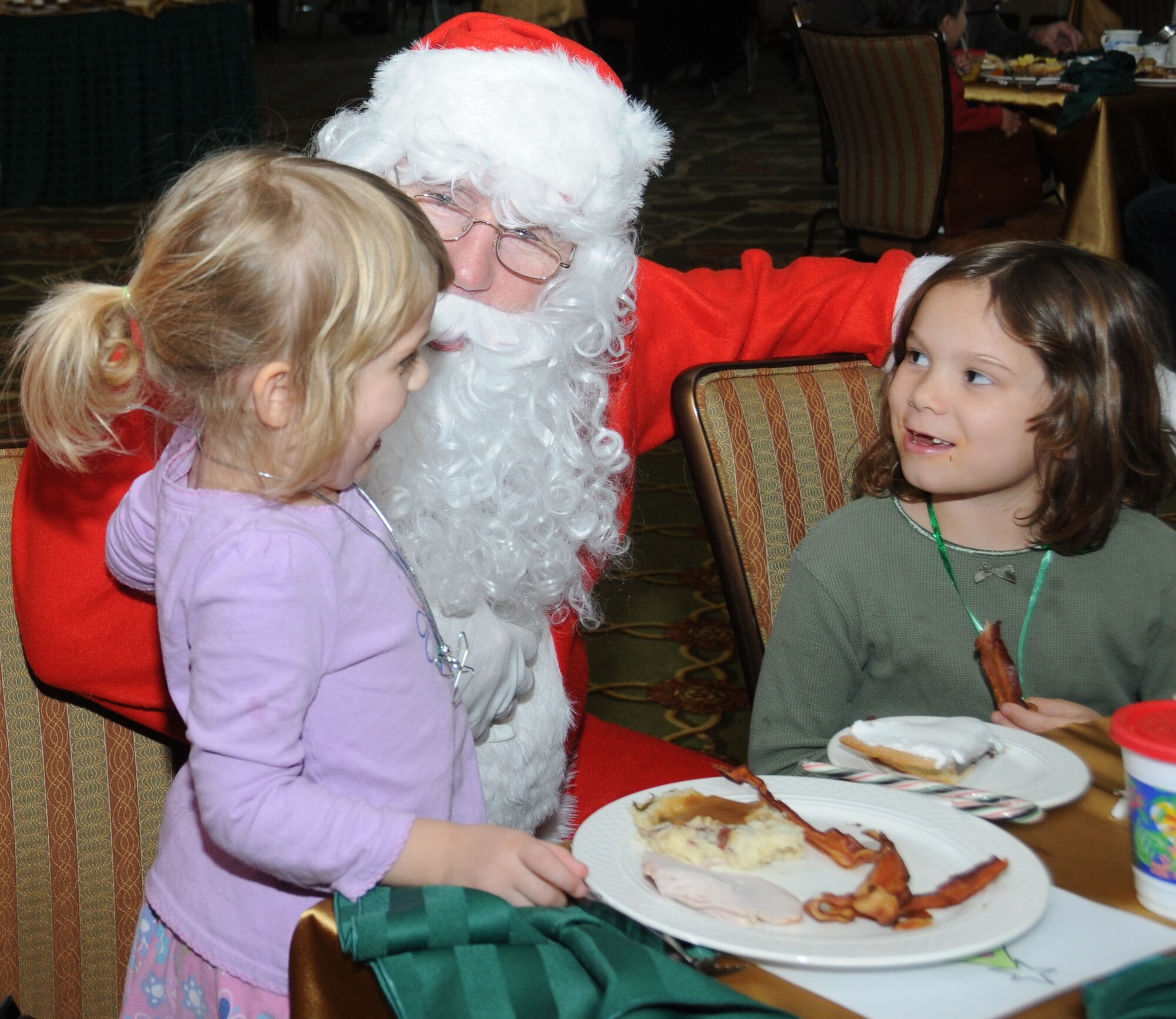 Juliana Burdge, left, and her sister, Elena, visit with Santa during Brunch with Santa, Dec. 19. Juliana, 4, and Elena, 6, are the daughters of Lt. Col. Eric and Tally Burdge, 81st Surgical Operations Squadron.  (U.S. Air Force photo by Kemberly Groue)