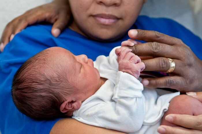 NELLIS AIR FORCE BASE, Nev.-Bernadette Merritt, wife of Tech. Sgt. TJ Merritt, 57th Aircraft Maintenance Squadron weapons expeditor, holds her newborn son, Kamali'i, as he grasps his father's fingers Jan. 4 at the Mike O'Callaghan Federal Hospital. Born Jan. 3 at 5:58 a.m., Kamali'i was the first child born at Nellis in 2011. (U.S. Air Force photo by Airman 1st Class George Goslin)
