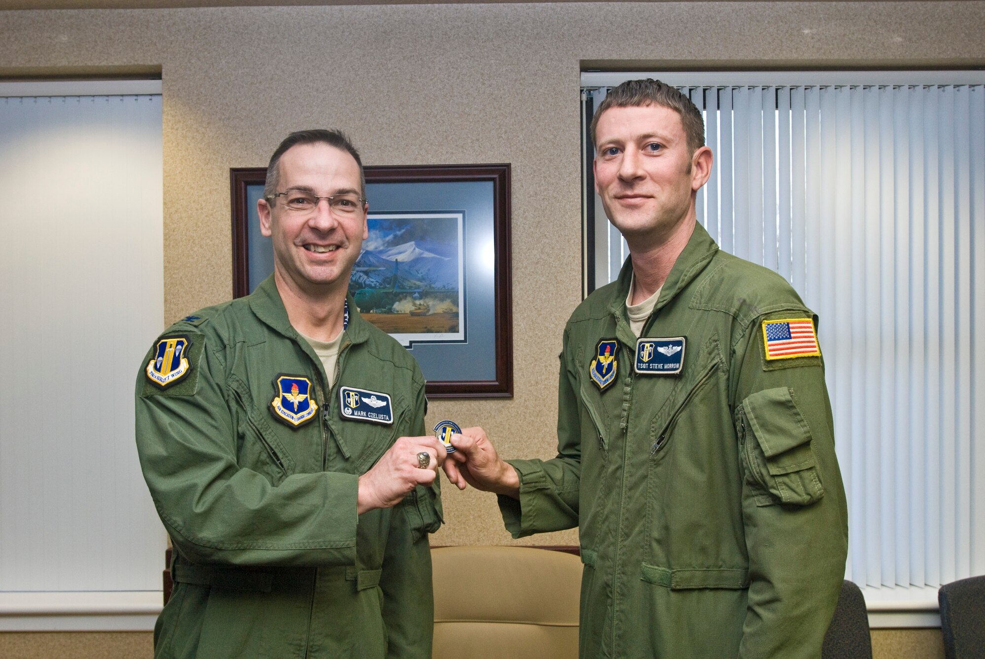 Col. Mark Czelusta (left), 314th Airlift Wing commander, presents a coin Wednesday to Tech. Sgt. Stephen Morrow, a 314th Operations Group C-130 flight engineer, for his selection as the Combat Airlifter of the Week. Sergeant Morrow volunteered his time organizing a 314th OG staff weekend project for Habitat for Humanity and currently serves as a head coach for a Jacksonville Parks and Recreation children’s football team. (U.S. Air Force photo by Staff Sgt. Nestor Cruz)