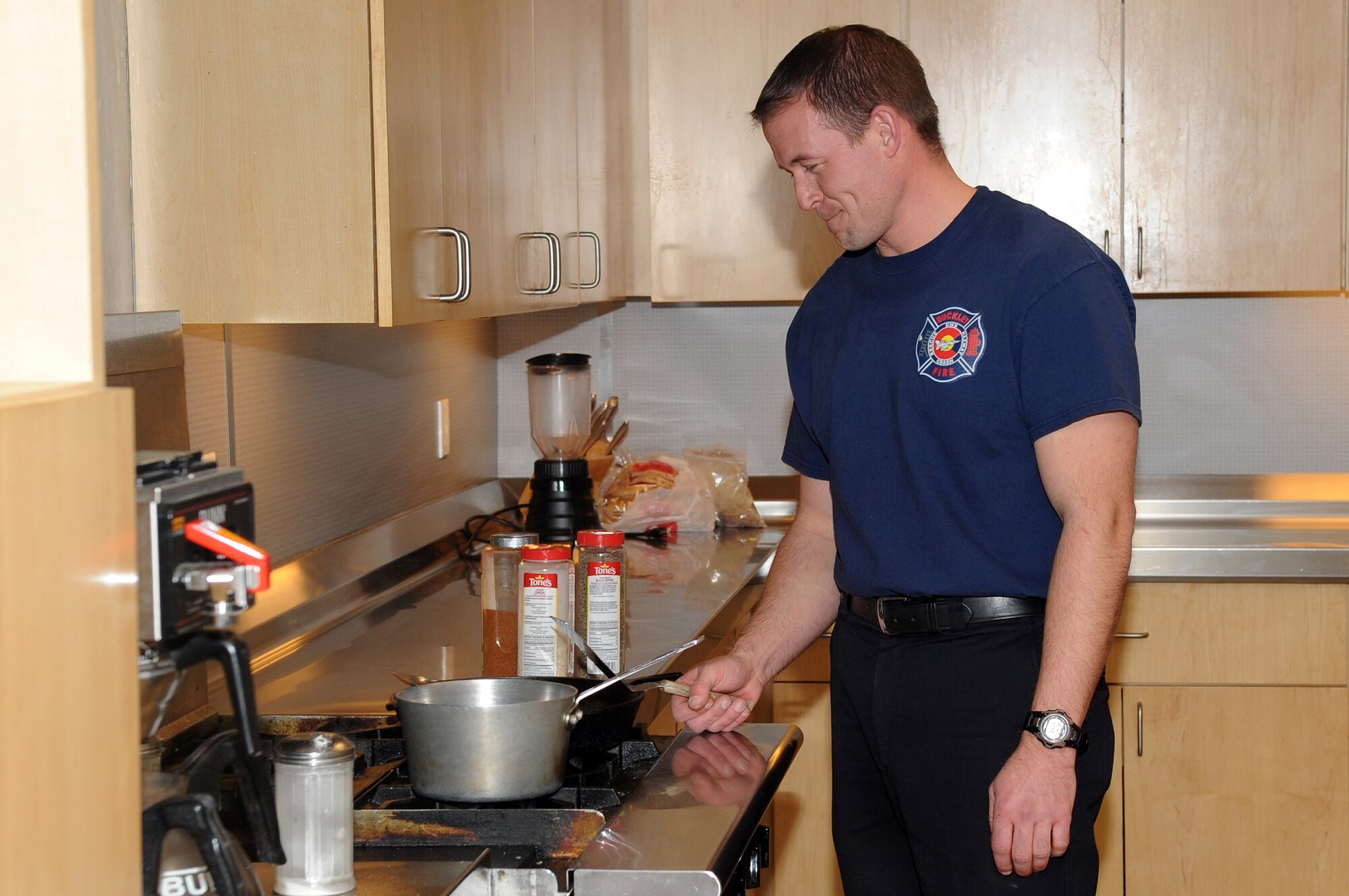 BUCKLEY AIR FORCE BASE, Colo.--Jason Debord, a fire fighter at Buckley Air Force Base cooks himself dinner, Jan. 4, 2011. Each fire fighter has to cook their own dinner and clean up after themselves, with the occasional fire station dinner where they all eat together. (U.S. Air Force photo by Airman Manisha Vasquez) 