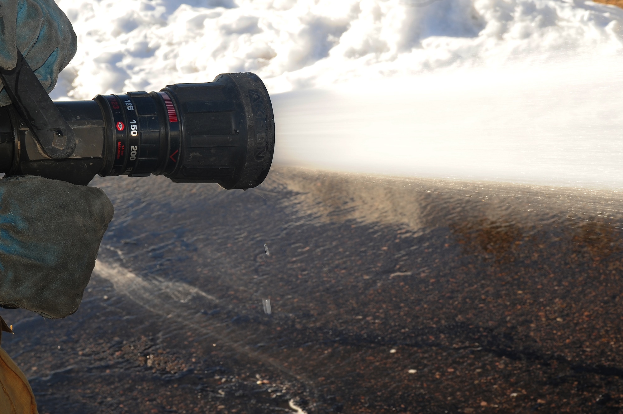 BUCKLEY AIR FORCE BASE, Colo.-- A fire hose from the main engine sprays about one-hundred and fifty pounds of water per square inch, Jan. 4, 2011. The buckley fire department get called for emergency's about five times a day on average. (U.S. Air Force photo by Airman Manisha Vasquez) 