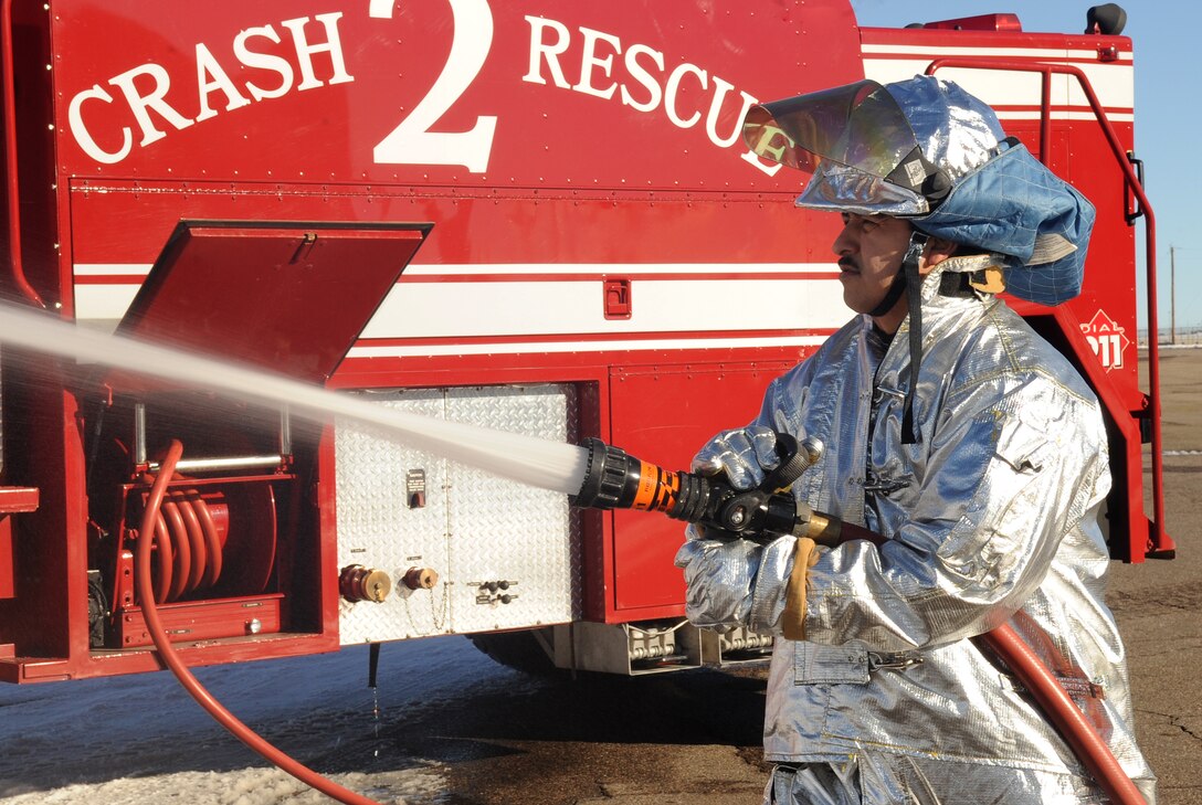BUCKLEY AIR FORCE BASE, Colo.-- Carlos Hidalgo from the Buckley Fire Department sprays water from one of the six trucks, Jan. 4, 2011. Each fireman works forty-eight hours on shift and seventy-two off.  (U.S. Air Force photo by Airman Manisha Vasquez) 