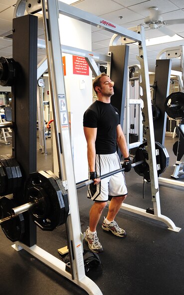 MOODY AIR FORCE BASE, Ga. -- Staff Sgt. Christopher Schultz, 820th Combat Operations Squadron parachute program manager, uses a Smith machine to perform shoulder shrugs Jan. 5.  Shoulder shrugs can be performed on a variety of machines and builds the shoulder and trapezius muscles. (U.S. Air Force photo/Senior Airman Stephanie Mancha)(RELEASED)