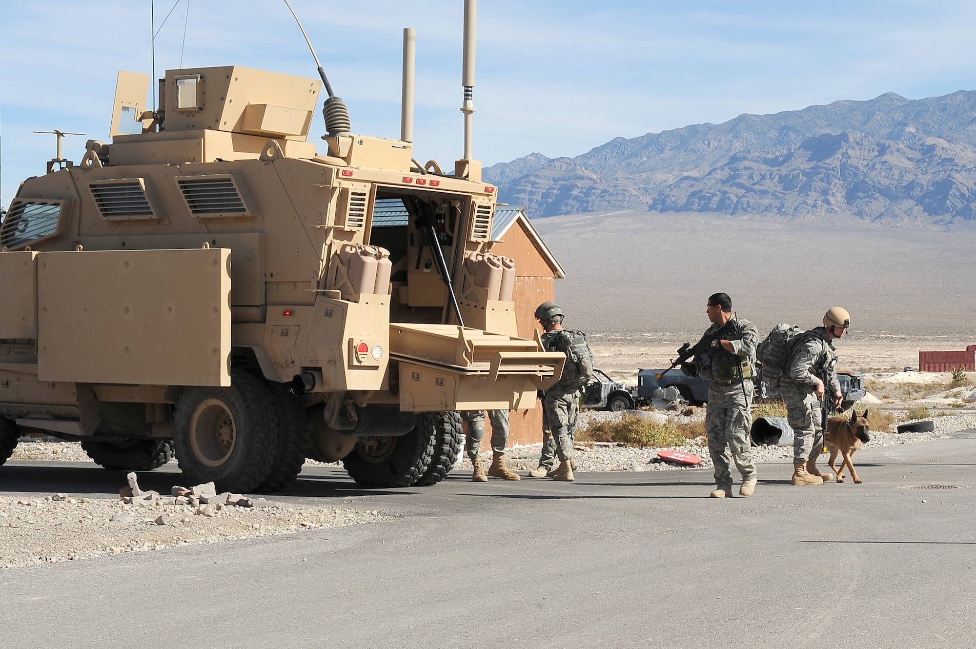 Security forces Airmen and their military working dogs secure the area after exiting a Mine Resistant Ambush Protected vehicle during a training exercise Oct. 29, 2010, at the Nevada Test and Training Range. The training exercise is part of a new Nellis Air Force Base, Nev., program created to condense the current 80 day training curriculum for handlers and MWDs. (U.S. Air Force photo/Airman 1st Class Daniel Hughes)