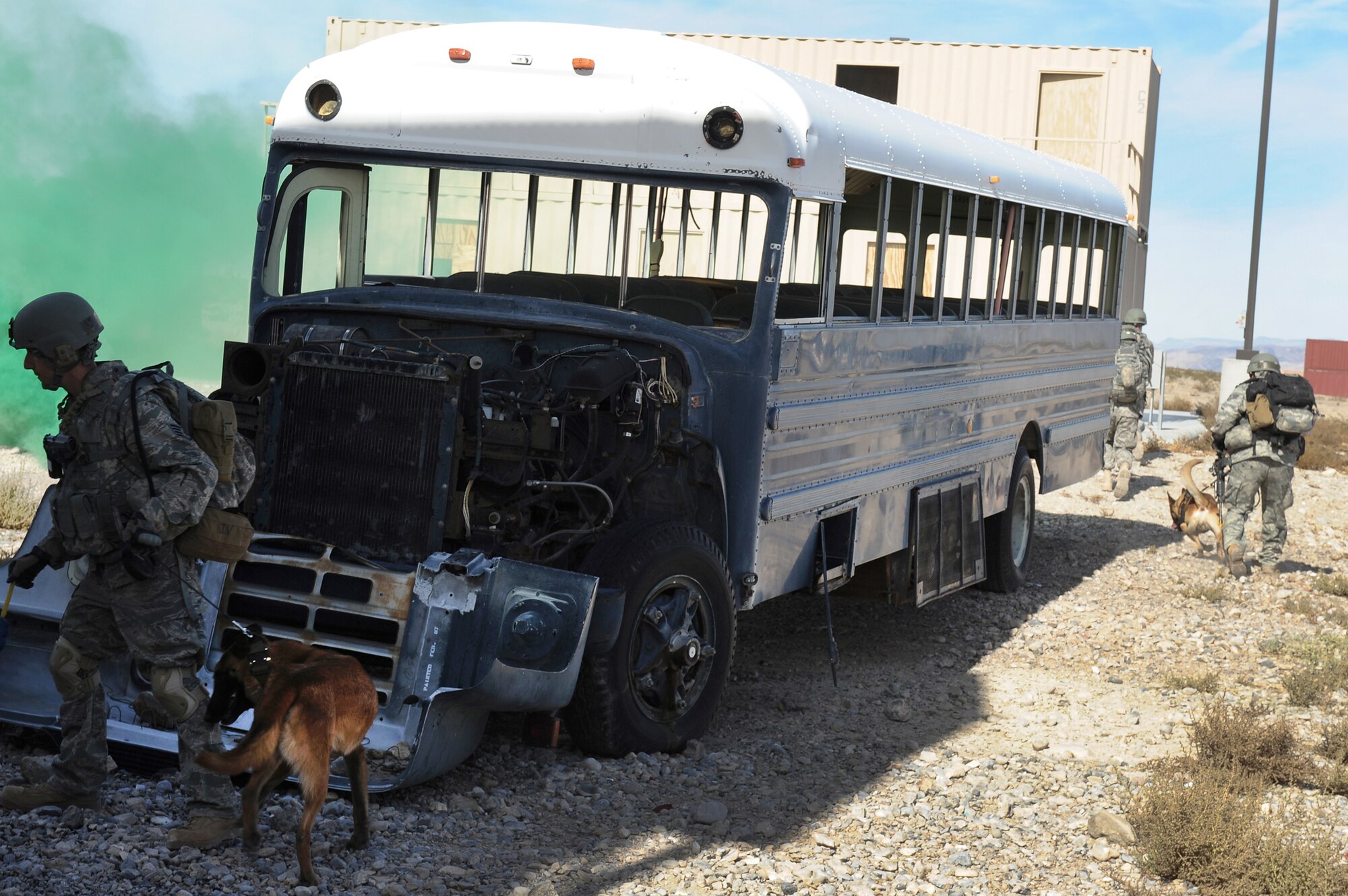 Staff Sgt. Ryan Stocklin and his military working dog Akim move around an abandoned bus during a training exercise Oct. 29, 2010, at the Nevada Test and Training Range. The training exercise is part of a new Nellis Air Force Base, Nev., program created to condense the current 80 day training curriculum for handlers and MWDs. Sergeant Stocklin is assigned to the 628th Security Forces Squadron at Charleston Air Force Base, S.C. (U.S. Air Force photo/Airman 1st Class Daniel Hughes)