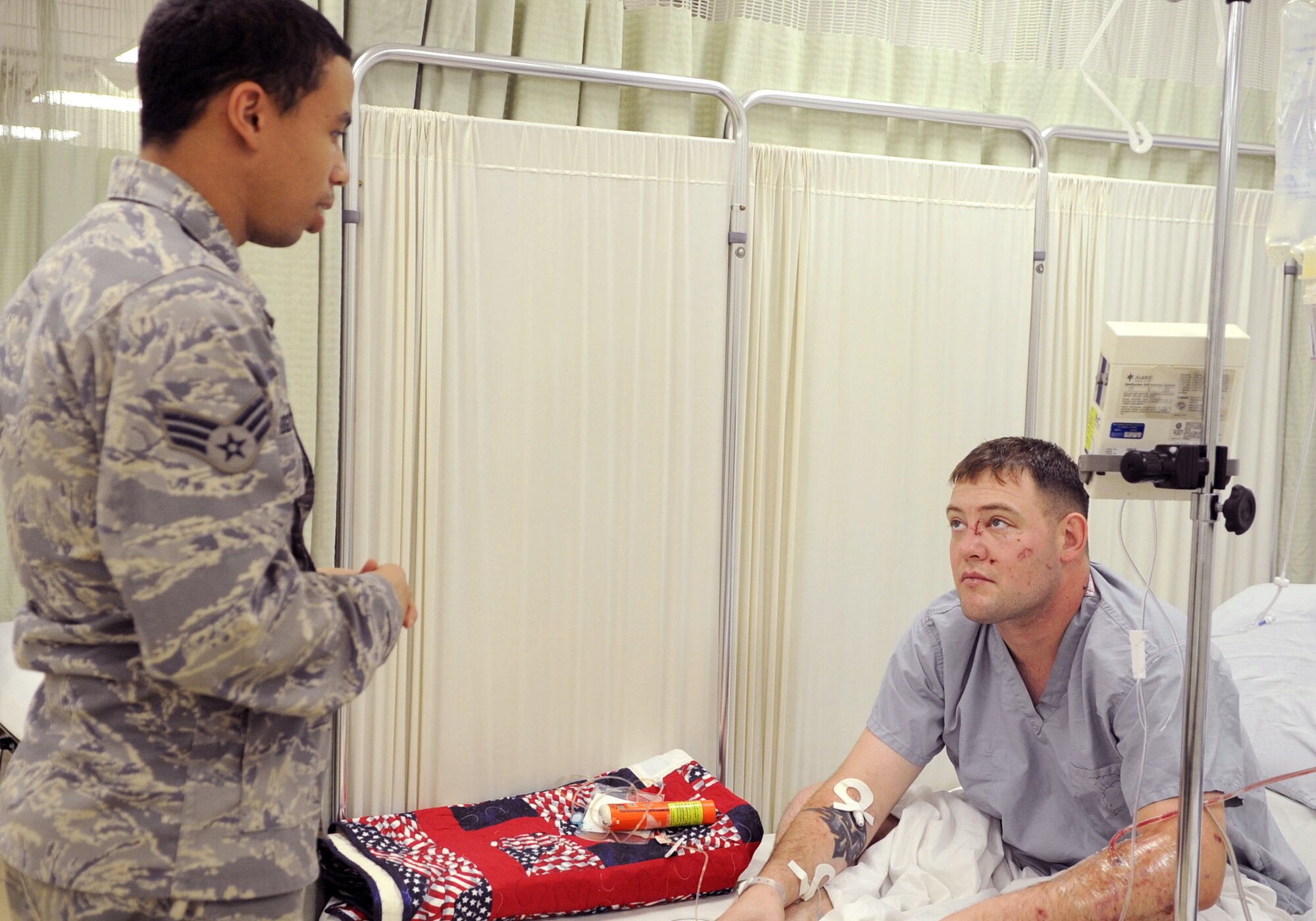 Senior Airman Greg Rodgers (left) visits recent Purple Heart recipient Army Cpl. Paul Vanlinder Jan. 4, 2011, at Joint Base Balad, Iraq. Corporal Vanlinder was admitted to the intensive care unit here after being injured in an improvised explosive device attack near Abu Sayada, Iraq. Airman Rodgers is a 332nd Expeditionary Medical Operations Squadron medical technician. Corporal Vanlinder is assigned to Charlie Company 1-21 Infantry Battalion.  (U.S. Air Force photo/ Staff Sgt. Keyonna Fennell)