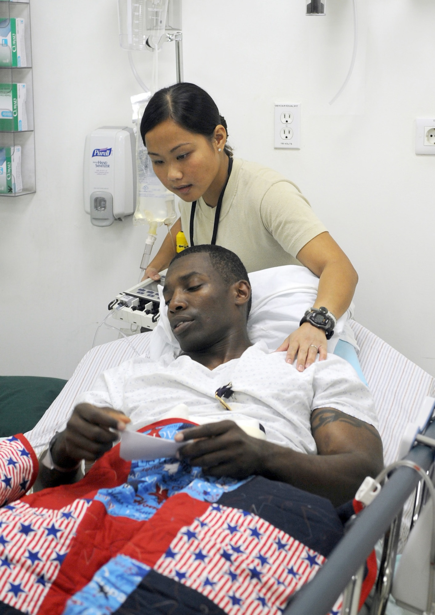 Staff Sgt. Frances Robinson comforts Army 1st Lt. Corey Bunch Jan. 4, 2011, at Joint Base Balad, Iraq. Lieutenant Bunch was admitted to the intensive care unit here after being injured in an improvised explosive device attack near Abu Sayada, Iraq. Sergeant Robinson is a 332nd Expeditionary Medical Operations Squadron medical technician. Lieutenant Bunch is assigned to Charlie Company 1-21 Infantry Battalion. (U.S. Air Force photo/Staff Sgt. Keyonna Fennell)