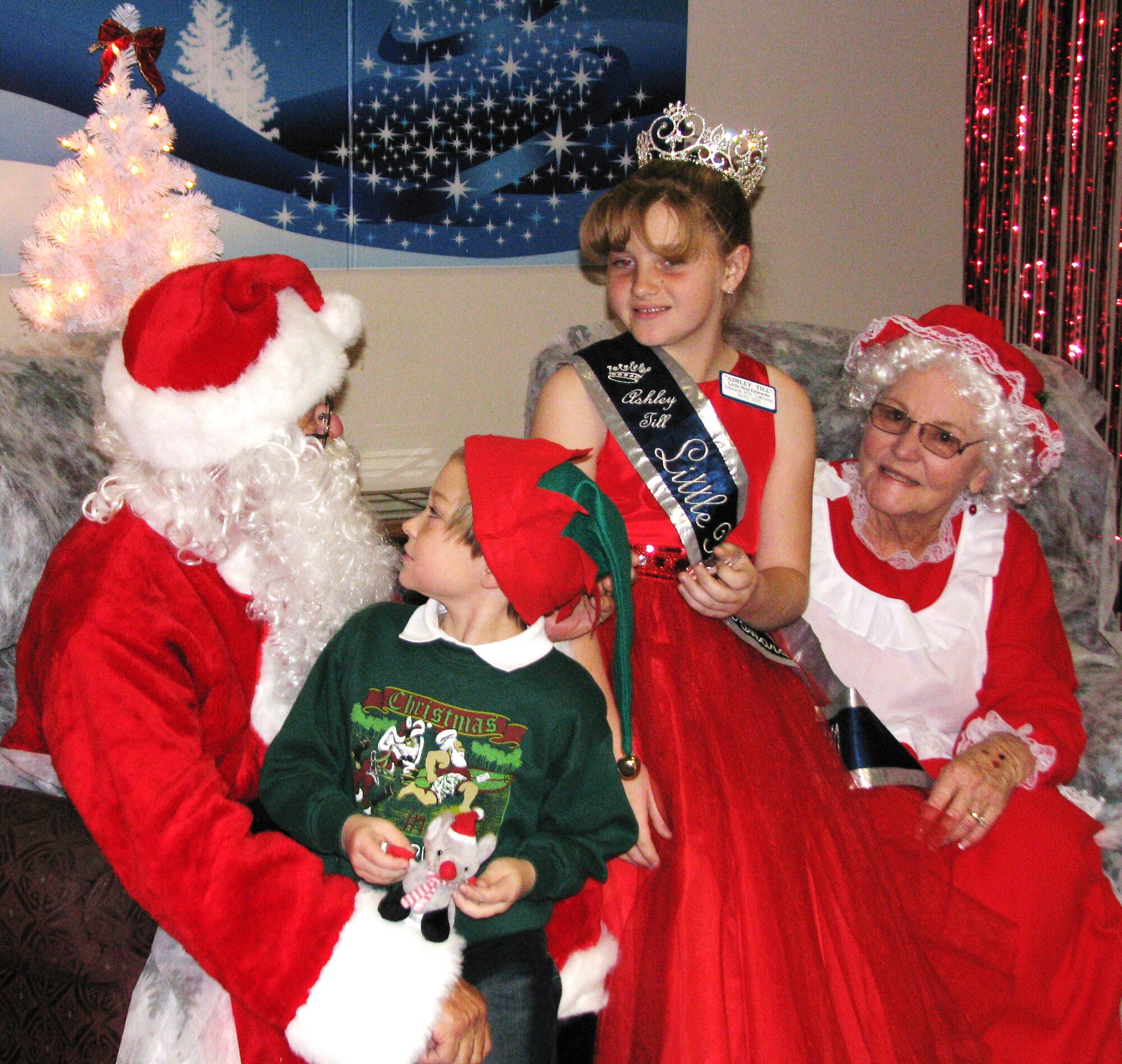 Ashley Till, 10, and her brother Jamie, 7, tell Santa and Mrs. Claus what they want for Christmas at the base wide holiday party. Ashley is Little Miss Edwards and Little Miss Photogenic 2010. (Air Force by Diane Betzler)