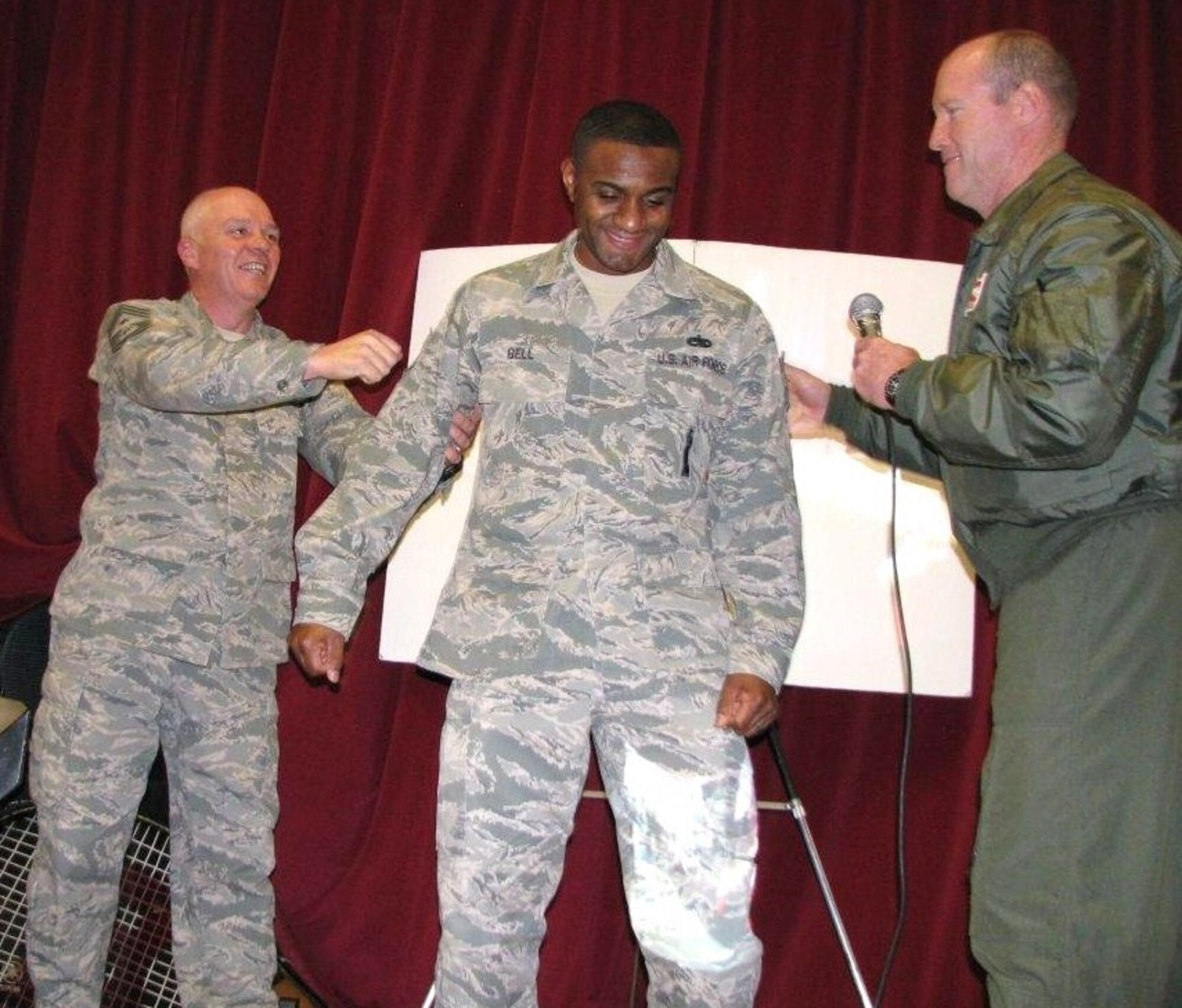 Cutline: Brig. Gen. Robert C. Nolan II, Air Force Flight Test commander (right) and Chief Master Sgt. Christopher S. McCollor, 412th Test Wing command chief (left), promote Staff Sgt. Geoff  Bell, 412th Maintenance Group,  to technical sergeant during this year's Edwards Holiday Party Dec.16. Sergeant Bell was selected for the promotion through the Stripes to Exceptional Performers Program, or STEP. The STEP program is a highly visible promotion recognition program used by commanders at all levels to recognize the outstanding contributions and accomplishments of enlisted personnel by awarding them with on-the-spot promotions. (Air Force photo by Diane Betzler)