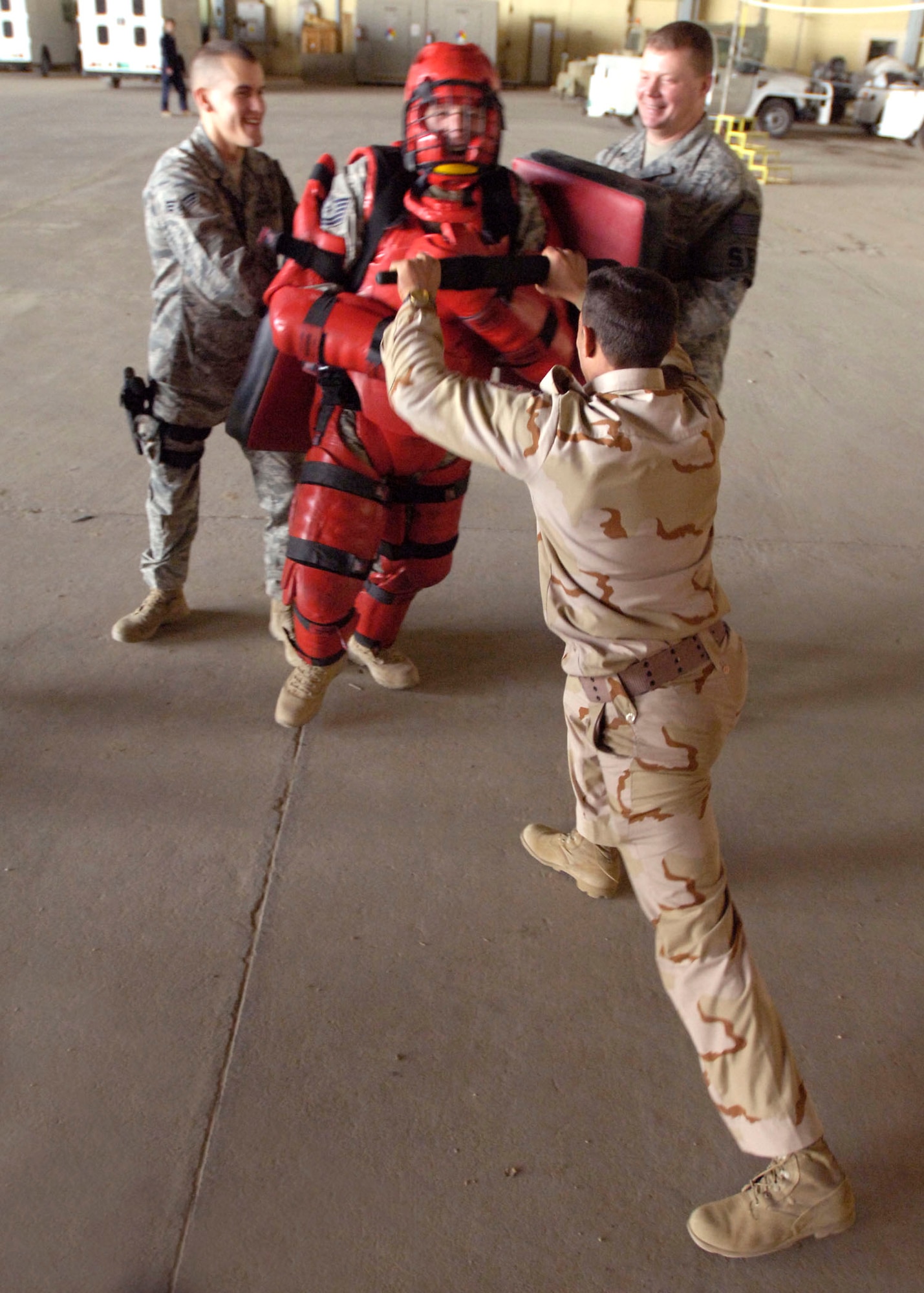 Tech. Sgt. Todd Barnett attacks an Iraqi air force airmen Dec. 23, 2010, during a training session. The Red Man suit helped provide a physical assault, but prevented any serious injuries during the training. Sergeant Barnett is a New Al-Muthana Air Base Transition Team member. (U.S. Air Force photo/Tech. Sgt. Randy Redman)