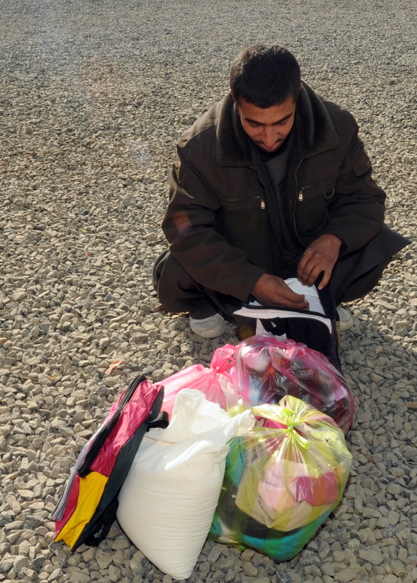 KABUL, Afghanistan - An Afghan contractors goes through the goods he received from members of the Afghan Air Force on the Afghan Air Force Base in Kabul, Afghanistan Jan. 5. (U.S. Navy photo by Mass Communications Specialist 3rd class Petty Officer Jared E. Walker/ RELEASED).