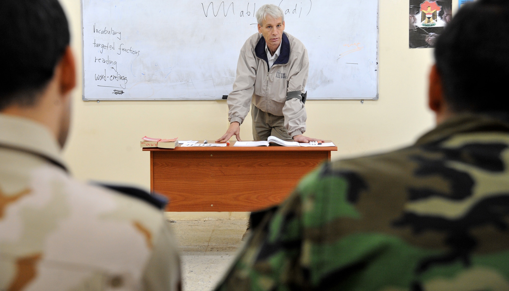 Arthur Nova, an instructor at the Iraqi Air Force Training School, teaches an advanced English language course to a class of Iraqi airmen Dec. 13, 2010, in Taji, Iraq. While air advisors work with the faculty to help them improve the way the overall program is run, it is the 19 U.S. contractors and lone DLI civilian who work face-to-face with the students. (U.S. Air Force photo/Senior Airman Andrew Lee)
