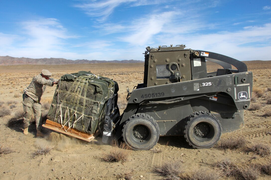 U.S. Army Sgt. Maj. Travis Votaw pushes a pallet of supplies onto a U.S. Navy bobcat during Operation Koranai Permakhtag at Bora Jengi checkpoint, Zabul province, Afghanistan, Dec. 25, 2010. Votaw is assigned to the U.S. Security Forces Advisory Team, 3rd Zone Afghan Border Police.