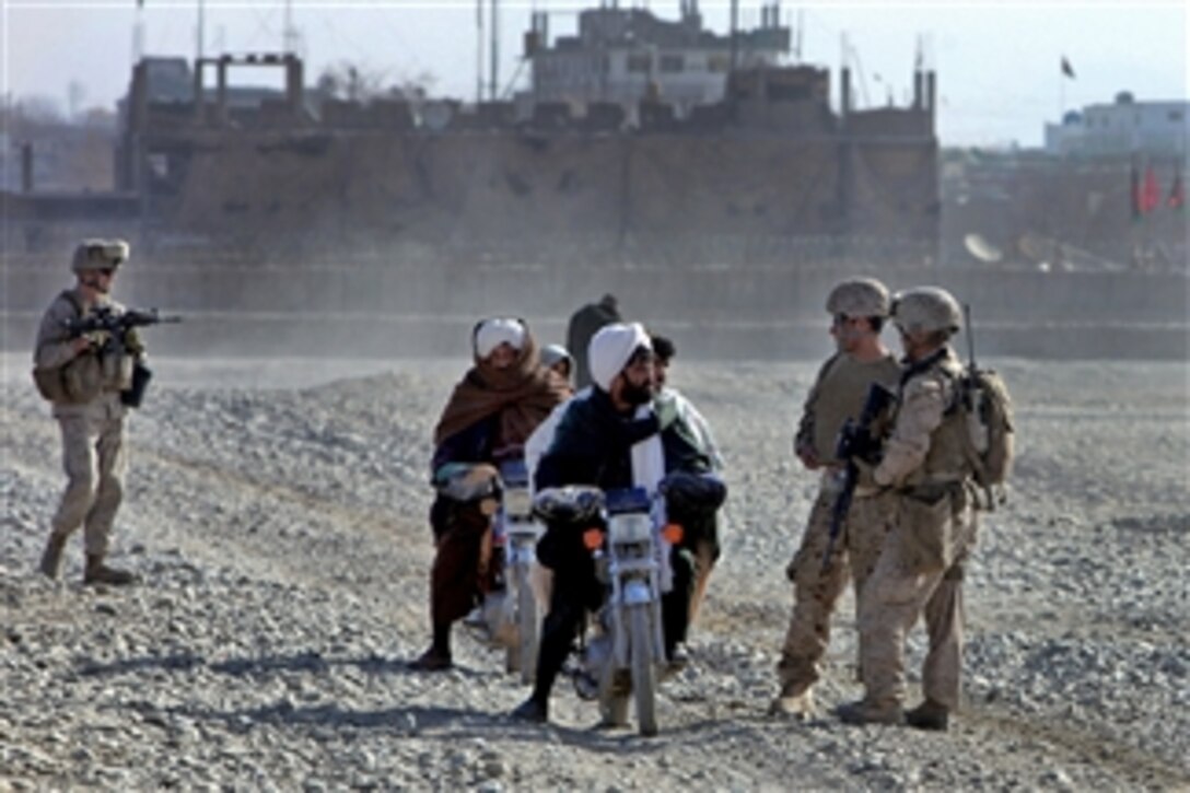 U.S. Marine Cpl. John Noh speaks to local Afghans during a patrol in Musa Qal’eh, Afghanistan, on Dec. 24, 2010.  Noh is assigned to the 1st Battalion, 8th Marines.  During the patrol, civil affairs Marines inspected several public works projects under construction throughout the district.  