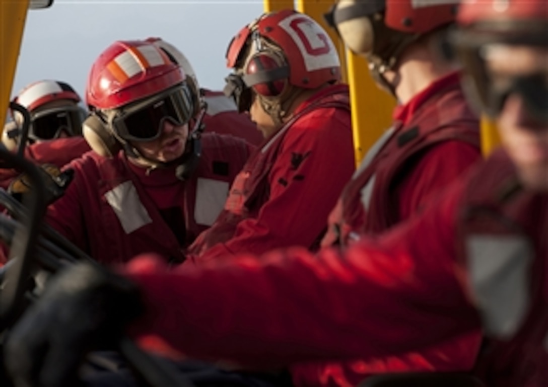 U.S. Navy Petty Officer 2nd Class Anthony Hedgepeth (2nd from left) directs other sailors as they prepare to move ordnance during a vertical replenishment aboard the aircraft carrier USS Carl Vinson (CVN 70) while the ship is underway in the Pacific Ocean during a routine deployment on Dec. 28, 2010.  