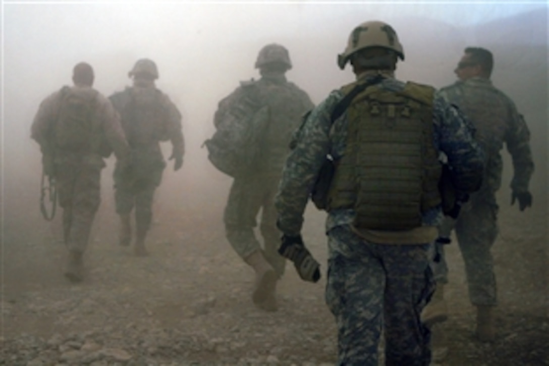 U.S. Army soldiers and Marines walk through rotor wash from a UH-60 Black Hawk Helicopter as they move toward a Forward Operating Base in the village of Darrah-I-Bum, Badghis province, Afghanistan Jan. 5, 2011. They accompanied the International Security Assistance Force Command Sergeant Major, Command Sgt. Maj. Marvin L. Hill on a visit to troops assigned to Special Operations Task Force-West living and working in Darrah-I-Bum.   