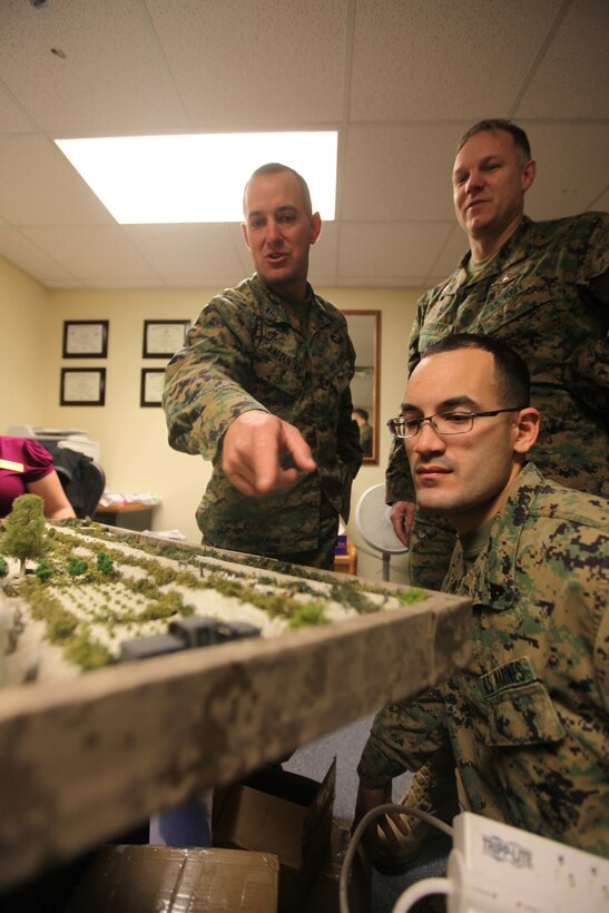 MARINE CORPS BASE CAMP LEJEUNE, N.C. - 1st Sgt. Philip Lafountain, with 2nd Battalion, 8th Marine Regiment, 2nd Marine Division, points out a vehicle he remembers from the Mian Poshteh area in Afghanistan where his unit was deployed to. Navy Lt. Terry A. Roberts, a chaplain with Marine Corps Base Camp Lejeune Chapel, who was the previous chaplain for 2/8 during their last deployment recently made a miniature model of the Mian Poshteh area complete with Marines, insurgents and animals.