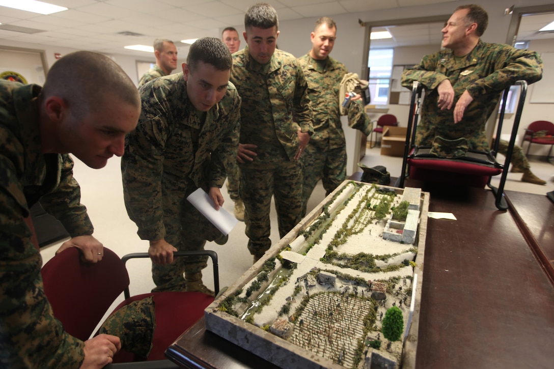 MARINE CORPS BASE CAMP LEJEUNE, N.C. - Marines with 2nd Battalion, 8th Marine Regiment, 2nd Marine Division, look at the miniature model of the Mian Poshteh area where 2/8's Echo Company was deployed to in Afghanistan. Navy Lt. Terry A. Roberts, a chaplain with Marine Corps Base Camp Lejeune Chapel, who was the previous chaplain for 2/8 during their last deployment recently made a miniature model of the Mian Poshteh area complete with Marines, insurgents and animals.