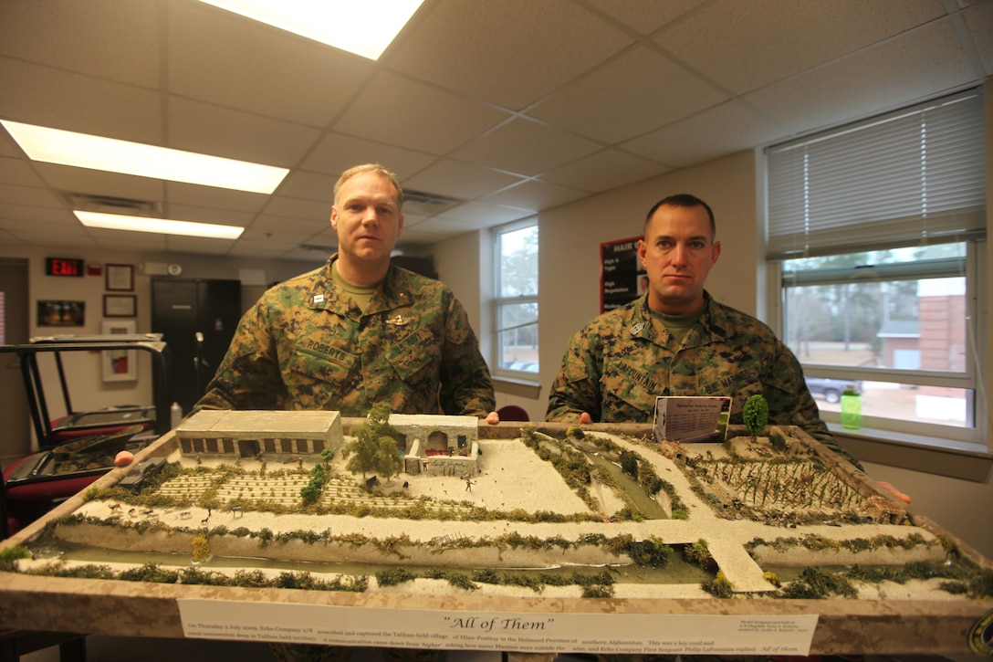 MARINE CORPS BASE CAMP LEJEUNE, N.C. - Navy Lt. Terry A. Roberts, a chaplain with Marine Corps Base Camp Lejeune Chapel, who was the previous chaplain for 2/8, stands with 1st Sgt. Philip Lafountain, as they hold up the display that Roberts made depicting Marines from 2/8's Echo Company in a firefight that occurred during their last deployment.