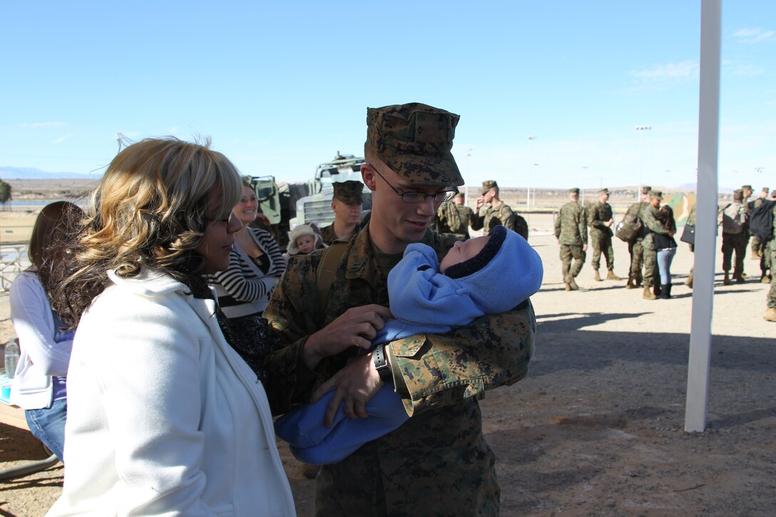 Sinead McNiel looks on as her husband, Seaman Justin McNiel holds his son, 2-month-old Matthew for the first time. McNiel, a corpsman with Battalion Landing Team 1st Battalion, 7th Regiment returned home Jan 6, 2011, from an eight-month long deployment.