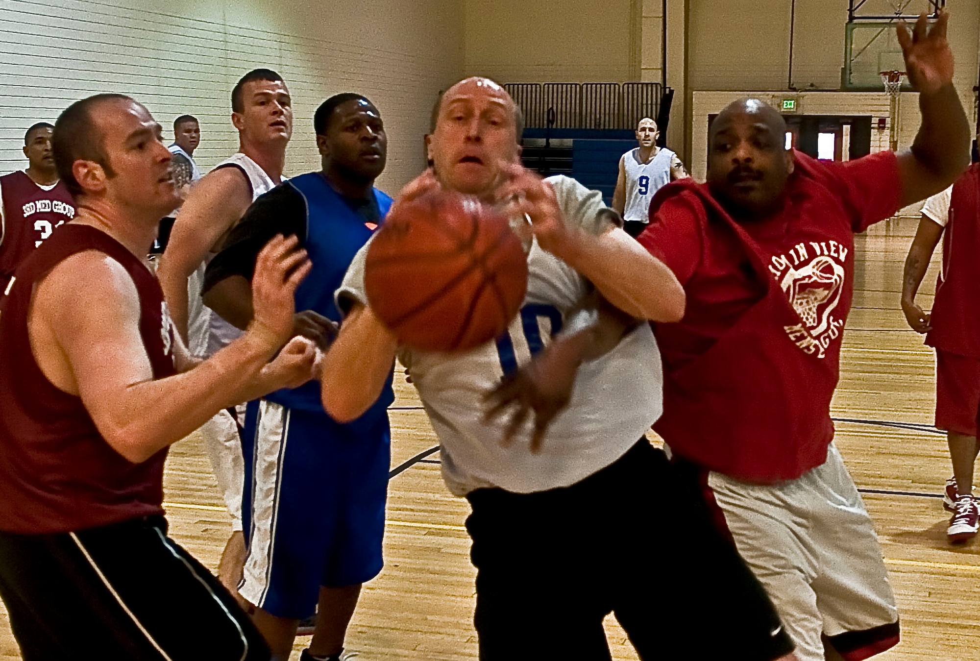 JOINT BASE ELMENDORF-RICHARDSON, Alaska -- From left to right, Nate Lewis, 673d Medical Support Squadron, Craig Von Holdt, 673d Civil Engineer Squadron and Nate Hale, 673d MDSS, go after a loose ball during a game of intramural basketball, Jan. 5, at the Fitness Center. The 673d MDSS came up big, winning the game with a score of 65 to 39. (Air Force photo by Airman 1st Class Christopher Gross)