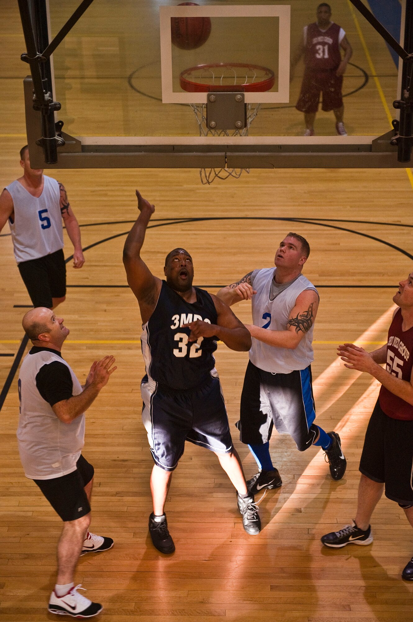 JOINT BASE ELMENDORF-RICHARDSON, Alaska -- Nate Hanzy, 673d Medical Support Squadron, lays the ball up against a couple of 673d Civil Engineer Squadron defenders during a game of intramural basketball Jan. 5 at the Fitness Center. The 673d MDSS came up big, winning the game with a score of 65 to 39. (Air Force photo by Airman 1st Class Christopher Gross)