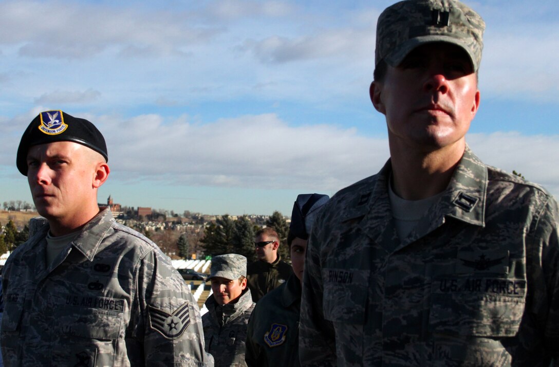 710th Security Forces Squadron Staff Sgt. Joseph Andrews, left, and 7SOPS Capt. Aaron Pinson stand at attention during the posting of colors at the Wreaths Across America ceremony at Fort Logan National Cemetery near Denver. The two Airmen were among nearly 30 who braved the frigid morning weather to lay wreaths on the graves of veterans on Dec. 11, 2010.