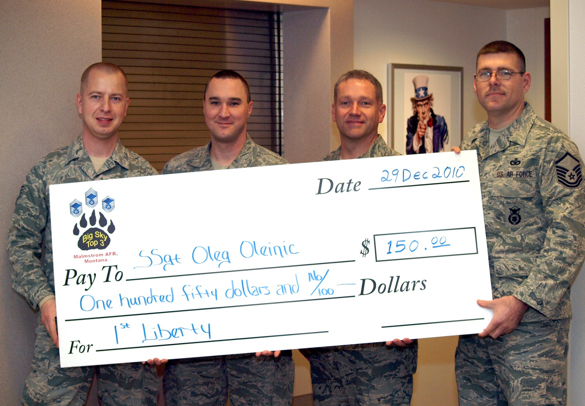 Staff Sgt. Oleg Oleinic (far left), 341st Medical Operations Squadron, was chosen as the quarterly Big Sky Top 3 scholarship winner, NCO category,  and is presented a check for $150 from Master Sgts. Christopher Smith, Jason Broach and Anthony Blum Dec. 29. The scholarship is funded by 1st Liberty Federal Credit Union and managed by the Big Sky Top 3.  One Airman and one NCO receive a check each quarter based on a two-page essay. Entries for the next quarter are due to Sergeant Blum by March 31. (Courtesy photo)