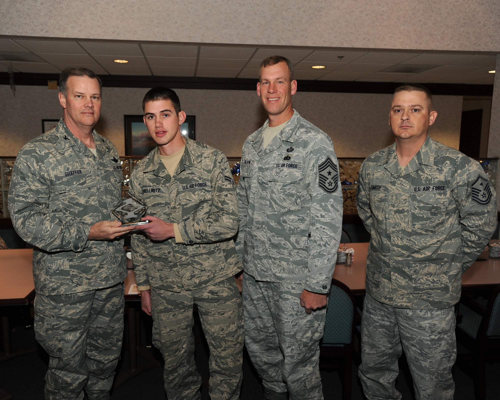 Col. Don Shaffer, 319th Air Refueling Wing Commander, presents Airman 1st Class Bryce Prellwitz, 319th Civil Engineering Squadron, with a Diamond Sharp Award Dec.16 at Airey Dining Facility here, accompanied by Command Chief Master Sgt. David Carlson, 319th Air Refueling Wing, and Master Sergeant John Smith, 319th Civil Engineering Squadron. The Diamond Sharp Award is given to those Airmen who epitomize service before self and strive for excellence at work and off duty. (U.S. Air Force photo by Staff Sgt. Suellyn Nuckolls)