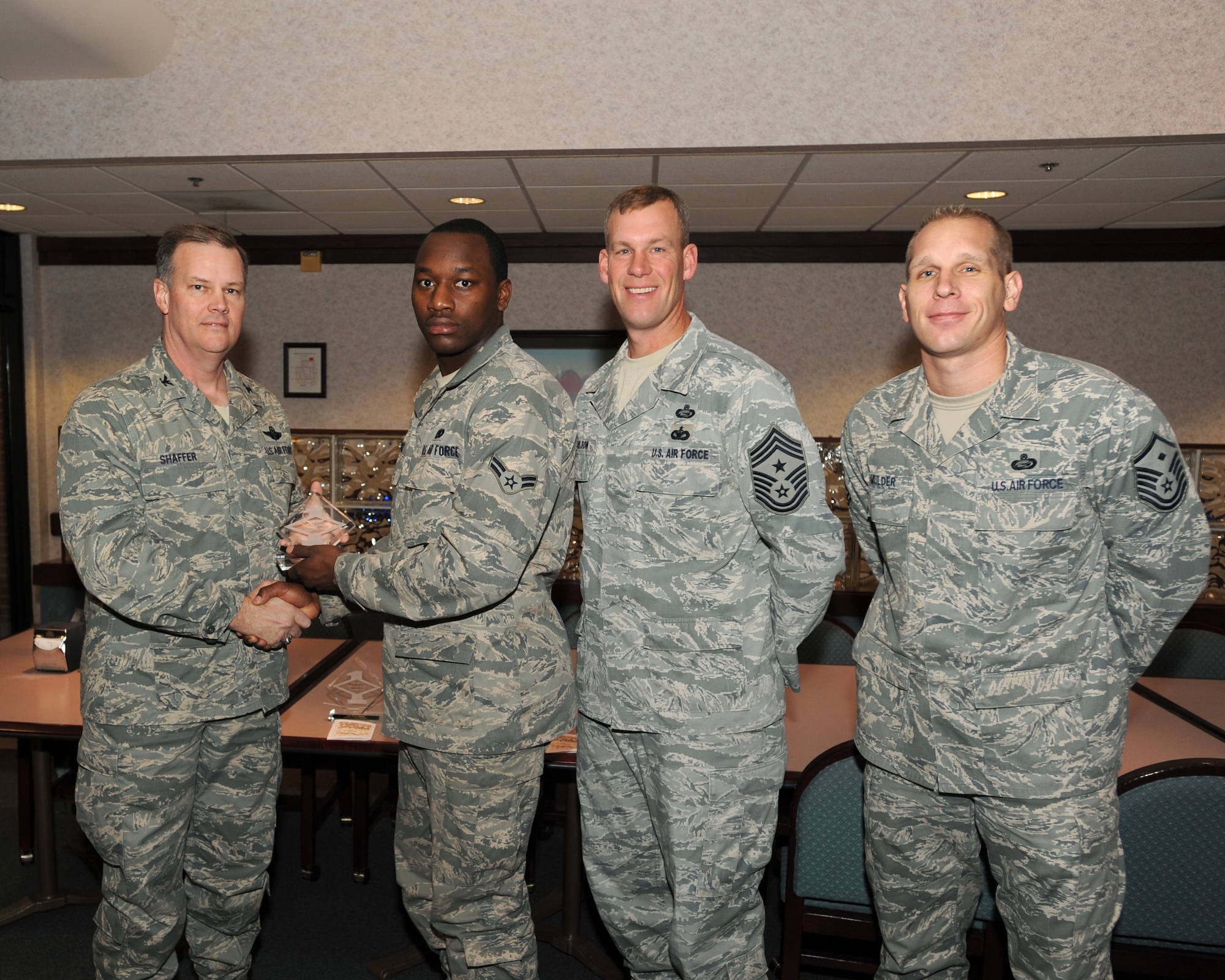 Col. Don Shaffer, 319th Air Refueling Wing Commander, presents Airman 1st Class Steven Bridges, 319th Logistics Readiness Squadron, with a Diamond Sharp Award Dec.16 at Airey Dining Facility here, accompanied by Command Chief Master Sgt. David Carlson, 319th Air Refueling Wing, and Master Sergeant Aaron Mulder, 319th Logistics Readiness Squadron. The Diamond Sharp Award is given to those Airmen who epitomize service before self and strive for excellence at work and off duty. (U.S. Air Force photo by Staff Sgt. Suellyn Nuckolls)
