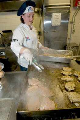Airman 1st Class Liana Taylor, 2nd Force Support Squadron food operations team member, places chicken on the grill while preparing for lunch at the Red River Dining Facility on Barksdale Air Force Base, La. Even more healthy food options have been added to the DFAC menu. (U.S. Air Force photo by Senior Airman Chad Warren)(RELEASED)