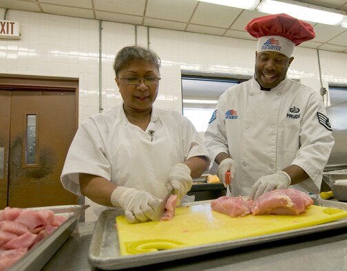 Staff Sgt. Jeremiah Prude, 2nd Force Support Squadron food operations team member, assists a fellow employee while preparing for lunch at the Red River Dining Facility on Barksdale Air Force Base, La. The Red River Dining Facility on Barksdale Air Force Base, La. has recently changed their menu to include even more healthy food options for Airmen. (U.S. Air Force photo by Senior Airman Chad Warren)(RELEASED)