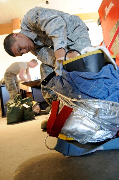 Airman Jose Gil, 2nd Civil Engineer Squadron firefighter, inspects his gear during a bunker inspection Jan. 6 at Barksdale Air Force Base, La. Firefighters perform bunker inspections at least once per month to ensure their equipment is in good working order and that it is all there. They inspect their equipment looking for tears, holes or anything that may hinder their safety. (U.S. Air Force photo/Staff Sgt. John Gordinier)