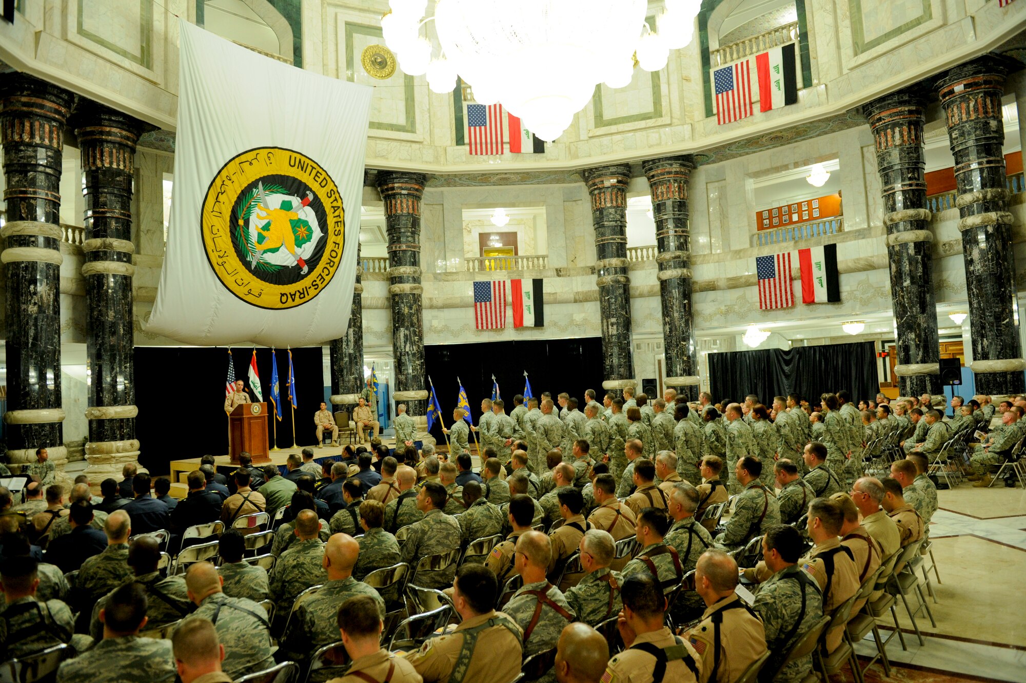 Members of the United States and Iraqi air forces listen to Brig. Gen. Scott Hanson, former 321st Air Expeditionary Wing commander and Director of Iraq Training and Advisory Mission - Air Force, give his departing speech at Al Faw Palace in Victory Base Complex, Baghdad, Jan. 6. Hanson led the 321st AEW team whose training and advising support for the Iraqi air force and has helped with their growth and development. (U.S. Air Force/Staff Sgt. Levi Riendeau)