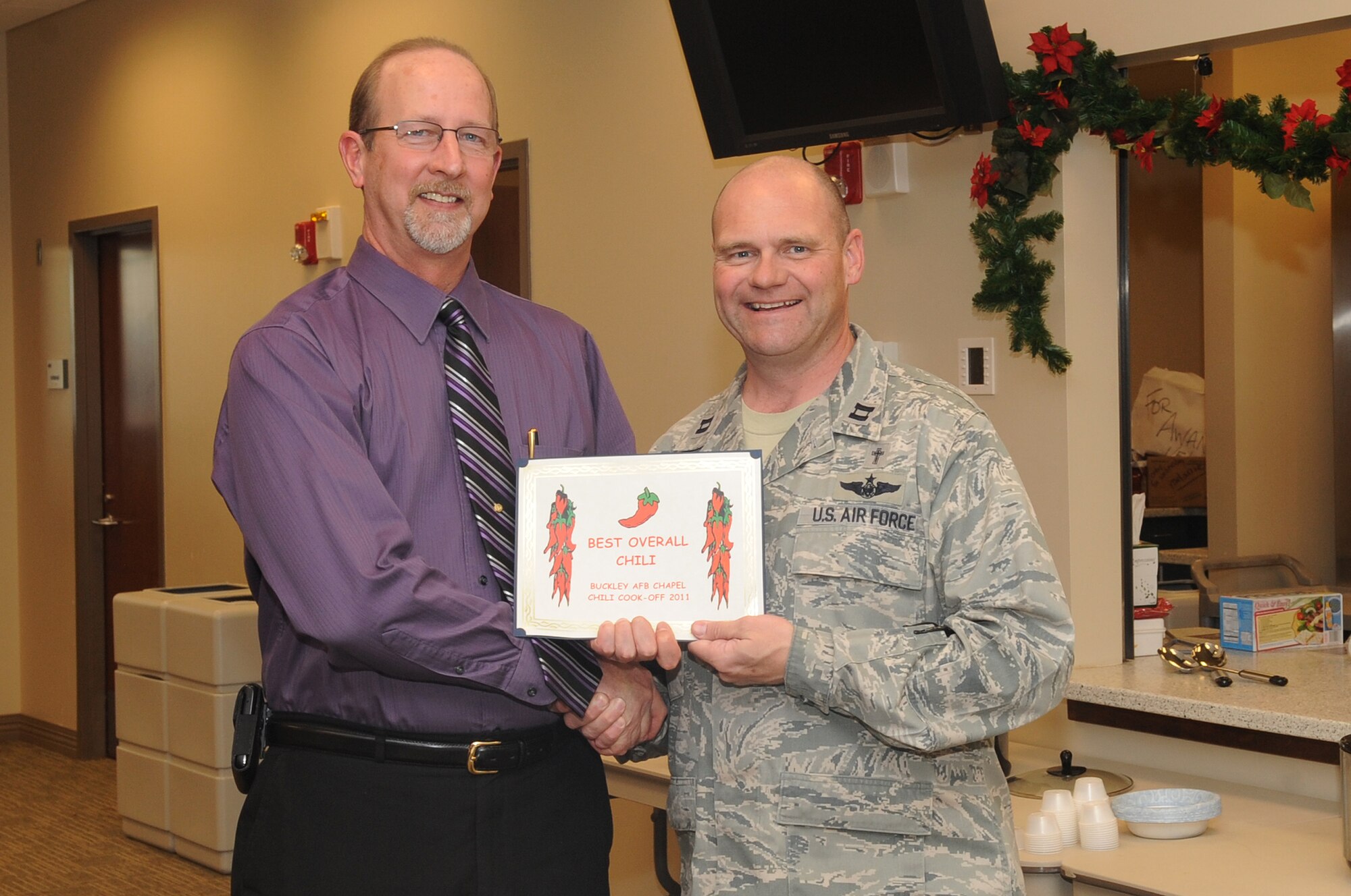 BUCKLEY AIR FORCE BASE, Colo.-- Duane Judy receives one of five awards during the annual chili cook-off at the chapel, Jan. 5, 2011. Mr. Judy won in the Overall Favorite Chili category of the competition. (U.S. Air Force photo by Airman Manisha Vasquez)