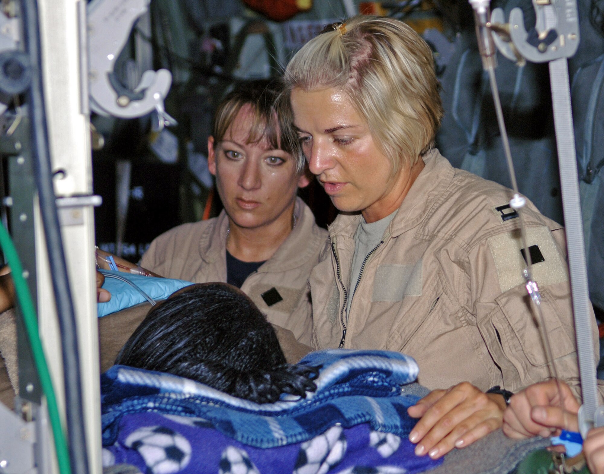 Master Sgt. Theresa Sheheen (left) and Capt. Michelle Mulberry tend to a litter patient on an aeromedical evacuation mission, from Bagram Air Base, Afghanistan. Sergeant Sheheen is a 455th Expeditionary Aeromedical Evacuation Flight medical technician and Captain Mulberry is a 455th EAEF flight nurse. (U.S. Air Force photo/Staff Sgt. Craig Seals)