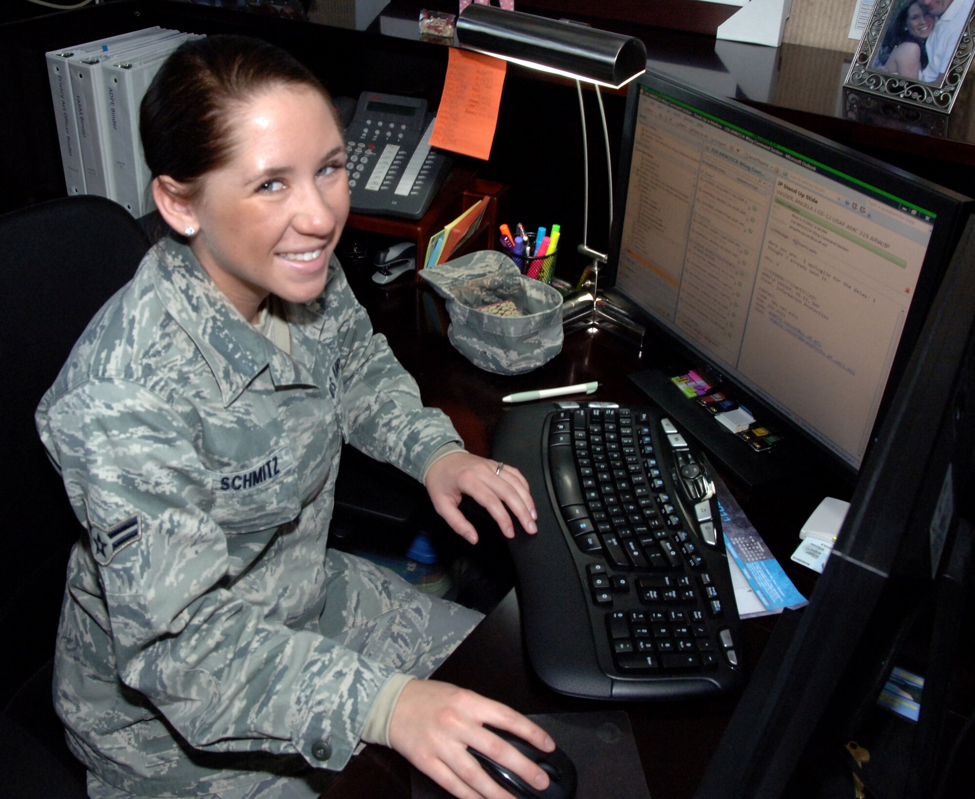 Airman 1st Class Courtney Schmitz, 319th ARW knowledge operations manager, poses for a photo at her desk Jan. 4 at the wing command building on Grand Forks Air Force Base, N.D. Airman Schmitz is the Warrior of the Week for the week of Jan. 3 to Jan. 7. Warrior of the Week recognizes every day Airmen, who work every day jobs. (U.S. Air Force photo by Airman Derek VanHorn)