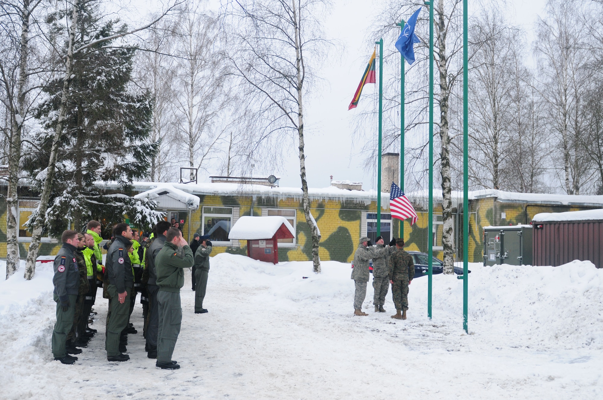 LITHUANIA AIR FORCE AIR BASE, Lithuania – A flag detail consisting of two Airmen and a Marine lower an American flag so a German flag can be raised during a ceremony, Jan. 5. The flag ceremony symbolized the 493rd Expeditionary Fighter Squadron relinquishing the Baltic air policing mission to the German air force. (U.S. Air Force photo/Staff Sgt. Stephen Linch)