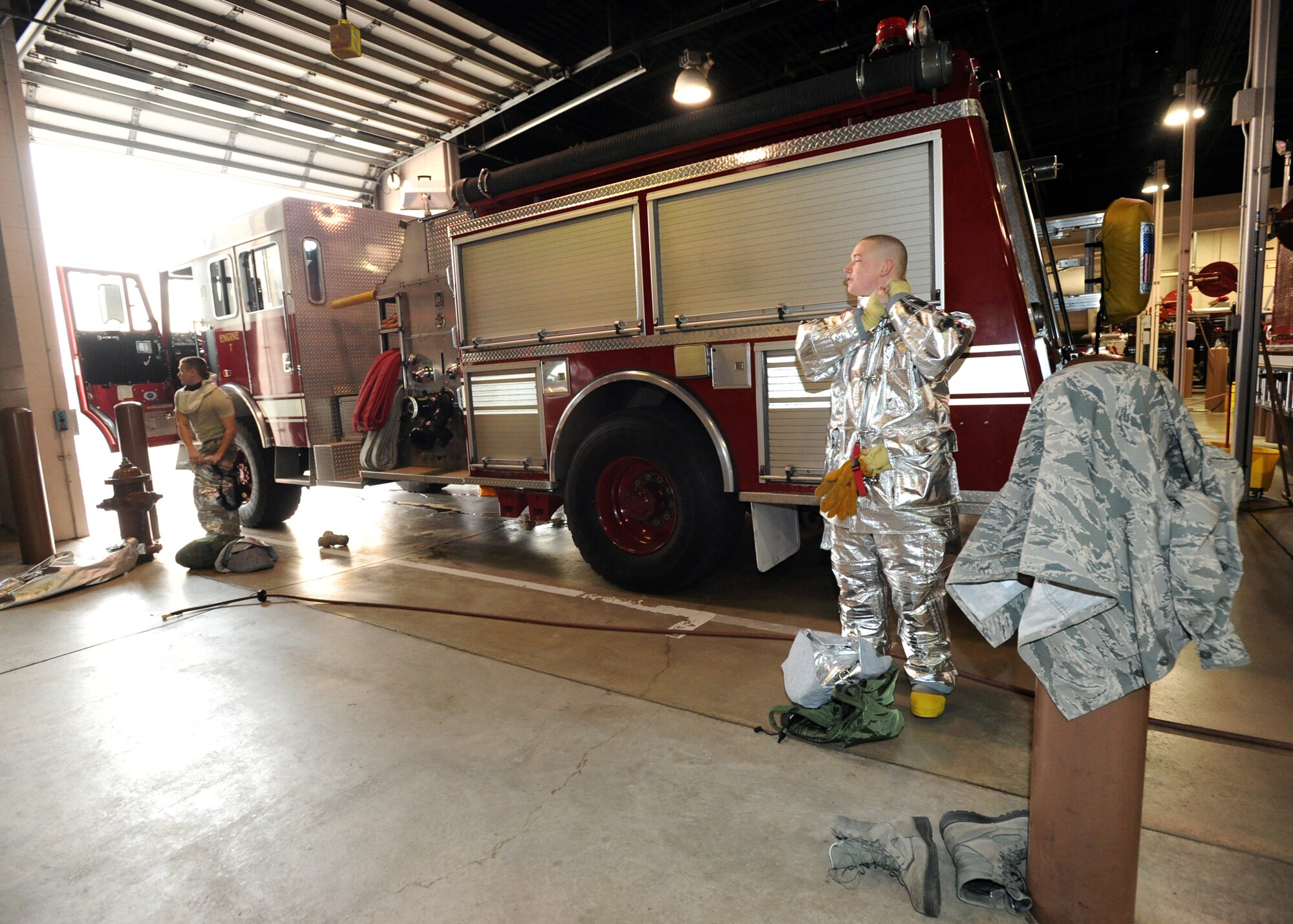 (Left to Right) Airman 1st Class William Turner and Airman 1st Class Dustin Wilkinson, 22nd Civil Engineer Squadron firefighters, put on their personal protective clothing, referred to as “turnout gear,” during an emergency response training task, Dec. 21, 2010, McConnell Air Force Base, Kan. The combination of modern triple-layer turnout gear makes it possible to survive and enter burning buildings. (U.S. Air Force photo/Airman 1st Andrea Salazar)