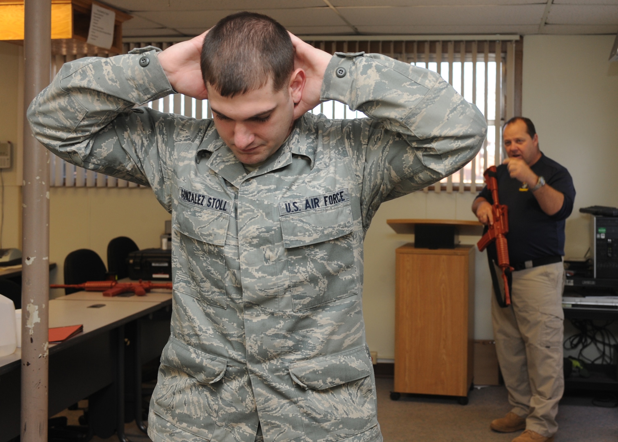 DYESS AIR FORCE BASE, Texas – Airman 1st Class Adrian Gonzalez-Stoll, 317th Airlift Group, stands at the position of disadvantage as Glenn Mitchell, 7th Security Forces Squadron trainer, teaches members of the 317 AG challenge procedures Jan. 5 during a security forces augmentee course held at the 7 SFS training building here. Members of the 317 AG are trained to be 7 SFS augmentees to provide additional installation security. (U.S. Air Force photo/Senior Airman Jenifer H. Calhoun)