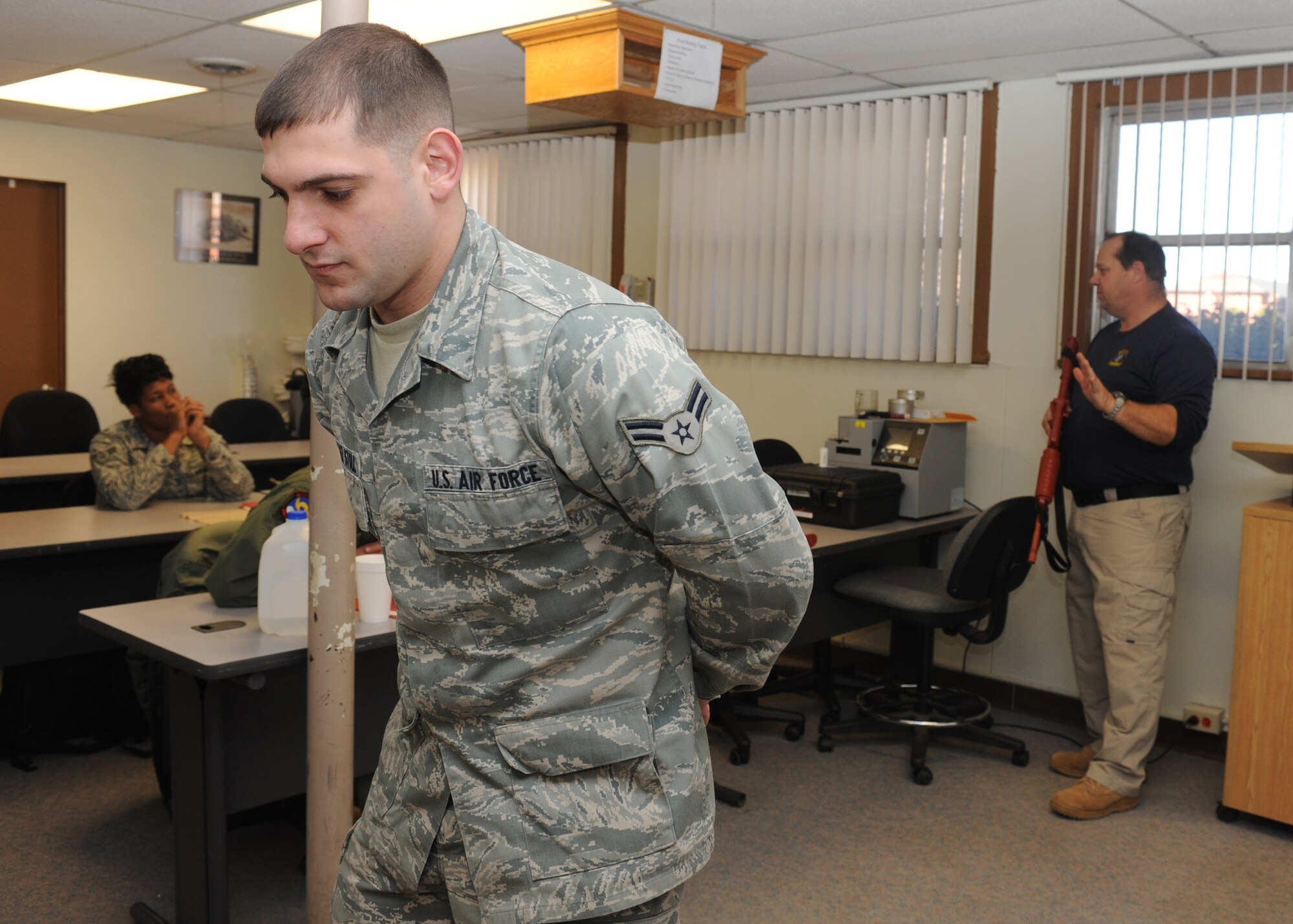 DYESS AIR FORCE BASE, Texas – Airman 1st Class Adrian Gonzalez-Stoll, 317th Airlift Group, stands at the position of disadvantage as Glenn Mitchell, 7th Security Forces Squadron trainer, teaches members of the 317 AG challenge procedures Jan. 5 during a security forces augmentee course held at the 7 SFS training building here. Members of the 317 AG are trained to be 7 SFS augmentees to provide additional installation security. (U.S. Air Force photo/Senior Airman Jenifer H. Calhoun)
