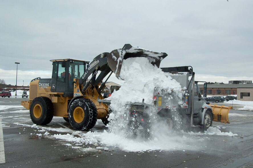 HANSCOM AIR FORCE BASE, Mass. – Snow is dumped into a dump trunk in the commissary parking lot on Dec. 29. Snow removal crews worked around the clock to remove snow from roads and parking lots after more than a foot of snow fell on Dec. 26 and 27. (U.S. Air Force photo by Rick Berry)