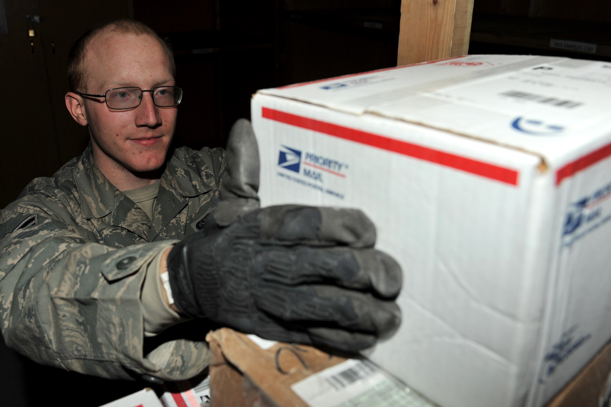 Airman 1st Class Patrick Smith, 455th Expeditionary Communications Squadron, sorts mail as it arrives in Camp Cunningham Mail Center at Bagram Airfield, Afghanistan, Jan. 6, 2011. The Camp Cunningham Mail Center receives an average of 24 pallets daily which handles all Air Force mail in the compound. Airman Smith is deployed to Bagram from Joint Base Charleston, S.C., and a native from New Castle, Ind. (Air Force photo/Senior Airman Sheila deVera)