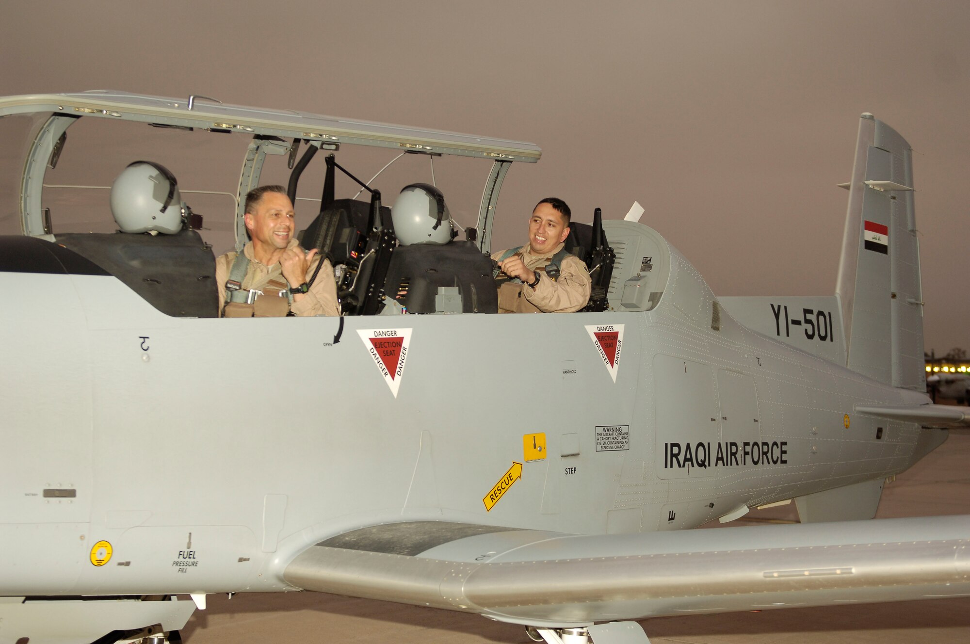Brig. Gen. Scott Hanson (left), Iraq Training and Advising Mission director, and 321st Air Expeditionary Wing commander, prepares to exit the cockpit of an Iraqi Air Force T-6 after his fini-flight Jan. 4 at New Al-Muthana Air Base, Iraq.  During his command, General Hanson conducted strategic level coordination with senior U.S., NATO and Iraqi leadership, to include the Minister of Defense and the Iraqi Air Force commander.(US Air Force photo by TSgt Randy Redman, released)