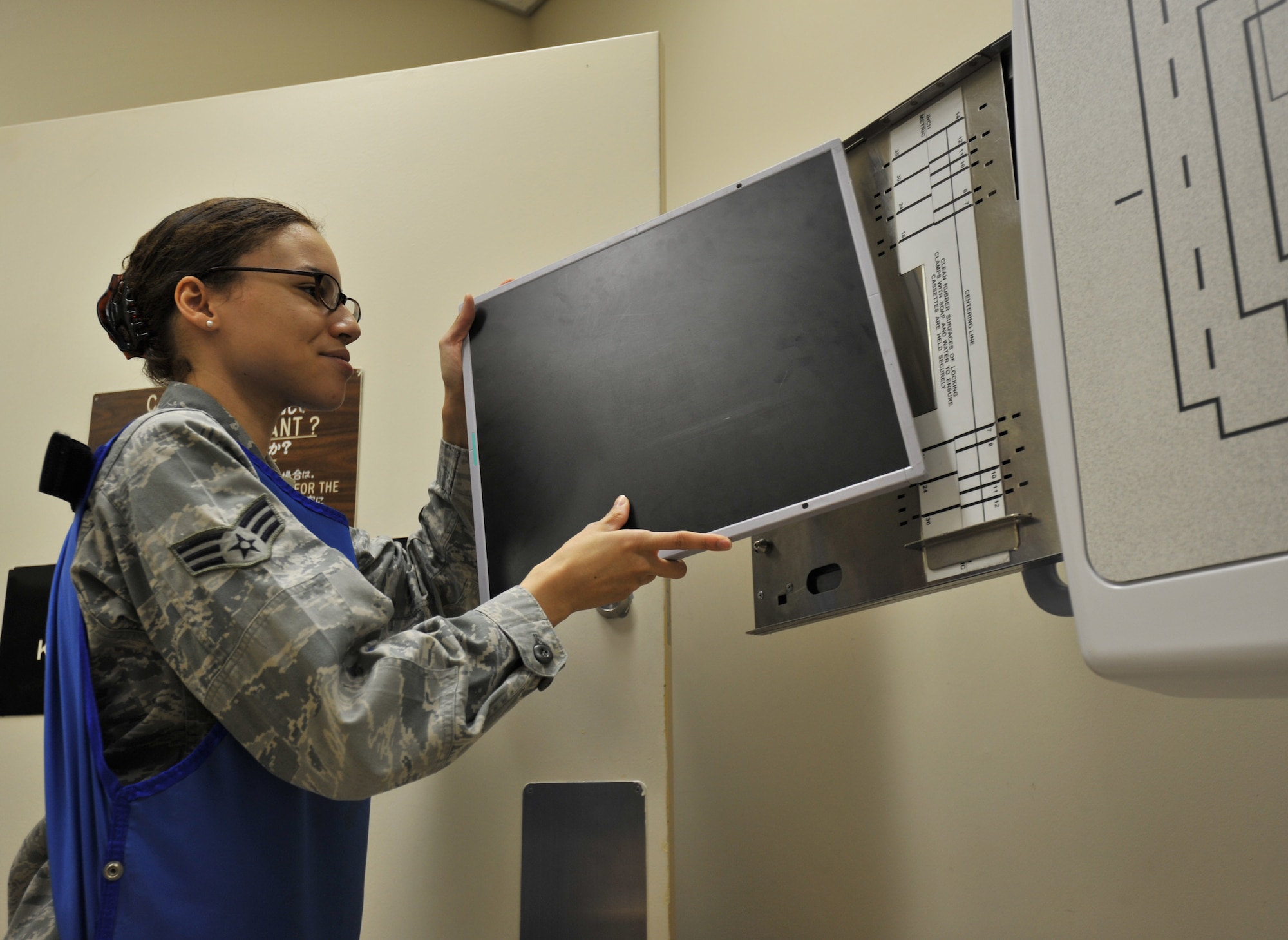 U.S. Air Force Senior Airman Natasha Bailey, 35th Surgical Operations Squadron diagnostic imaging technician, loads a radiography plate into an X-ray film holder Jan. 4, 2010; Misawa Air Base, Japan. After the X-ray is captured, the plate is scanned and the image is digitally transferred to a computer for viewing. (U.S. Air Force photo by Airman James B. Bauer/Released)