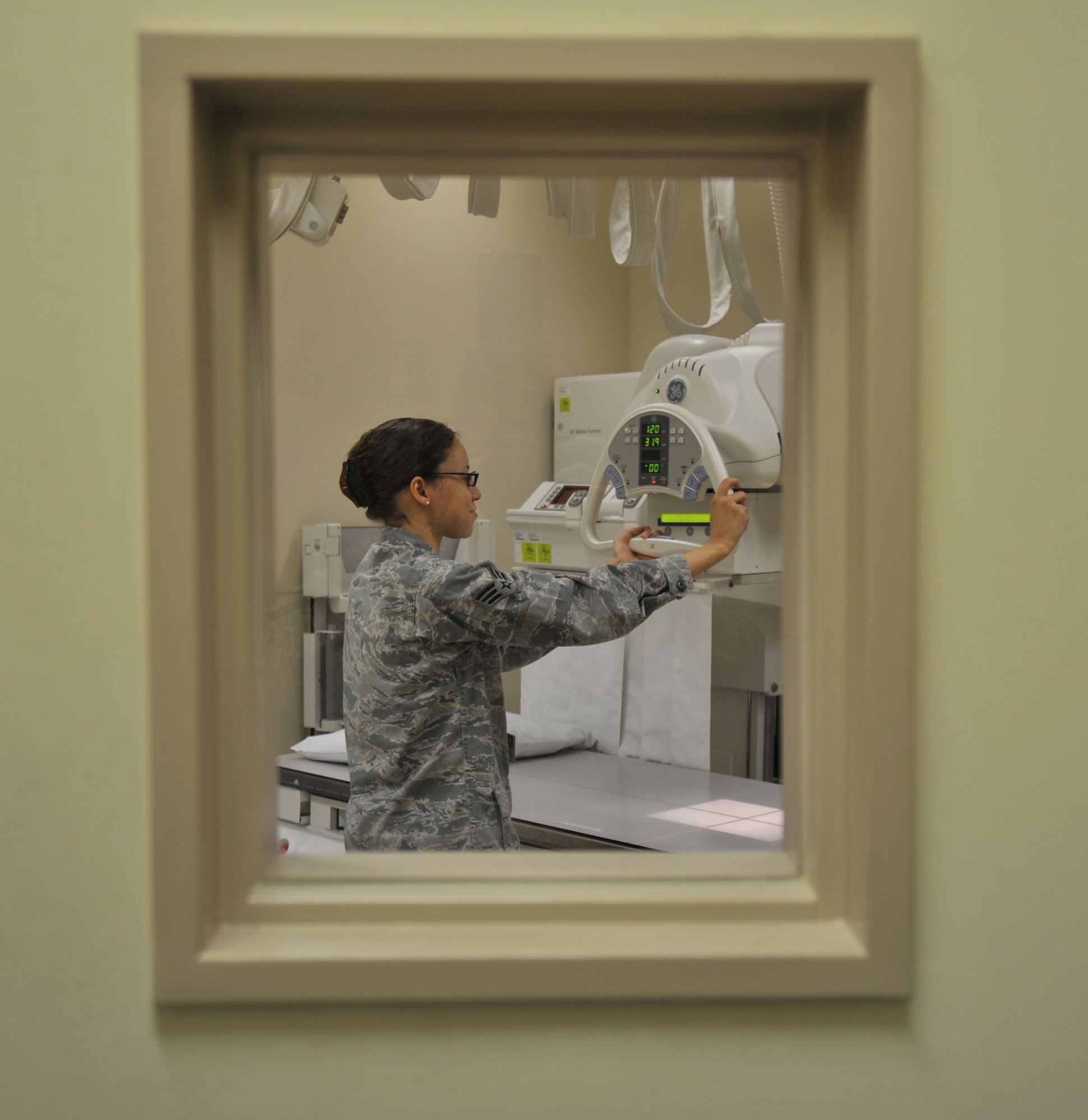 U.S. Air Force Senior Airman Natasha Bailey, 35th Surgical Operations Squadron diagnostic imaging technician, prepares an X-ray machine for the next patient Jan. 4, 2010; Misawa Air Base, Japan. The X-ray tube must be a specific distance from the table due to the magnification of the beam. (U.S. Air Force photo by Airman James B. Bauer/Released)