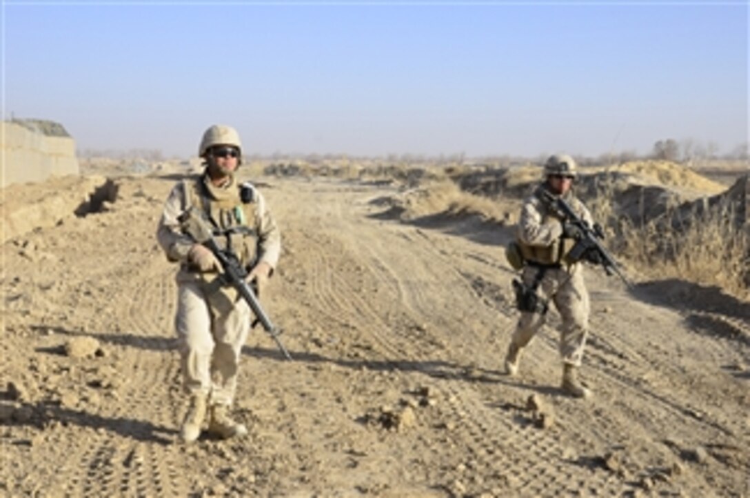 Petty Officer 1st Class Steven Maldonado and Gunnery Sgt. Javier Vega, both assigned to Naval Mobile Construction Battalion 40, conduct a perimeter security check around a new combat outpost in Diwar, Afghanistan, on Dec. 18, 2010.  Active duty and reserve component Seabees assigned to Naval Mobile Construction Battalions 40 and 18 secure and fortify a combat outpost in Diwar, Afghanistan.  