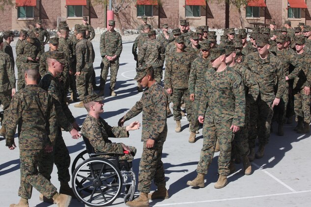 Corporal Jonathan Dowdell’s former unit, Company K, 3rd Battalion, 7th Marine Regiment, gathers around to congratulate him Jan 7, 2011, after receiving  a Navy Marine Corps Achievement  Medal with Combat distinguishing Device for bold actions and courageous sacrifice in support of Operation Enduring Freedom while he was deployed with the unit in June.